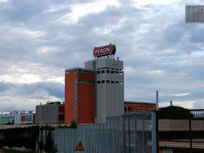 Con la sua altezza e i suoi colori grigio/rosso mattone, la fabbrica spicca tra i campi incolti circostanti